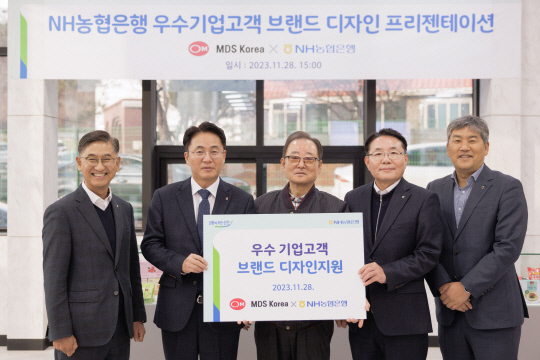 지난 28일 경기 파주시 소재 MDS코리아에서 열린 브랜드 디자인 지원 현판식 행사에서 이석용(왼쪽 두번째) 농협은행장, 문동준(가운데) MDS코리아 대표이사 등이 기념촬영을 하고 있다. 농협은행 제공.